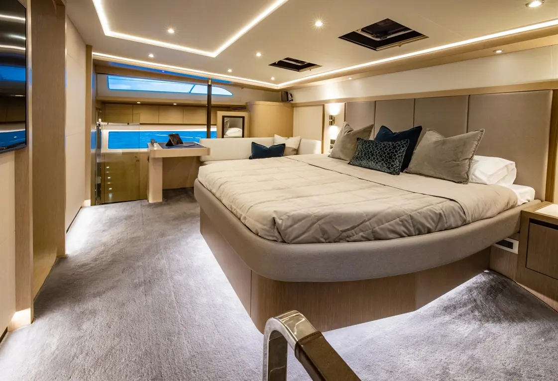 Luxurious boat bedroom featuring a large bed, stylish decor, and a view of the sea through large windows.